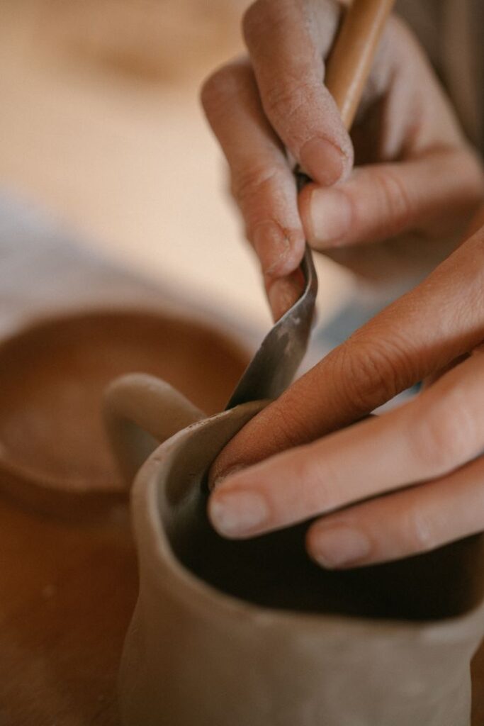 Artisan shaping pottery, showcasing craftsmanship in a creative studio setting.